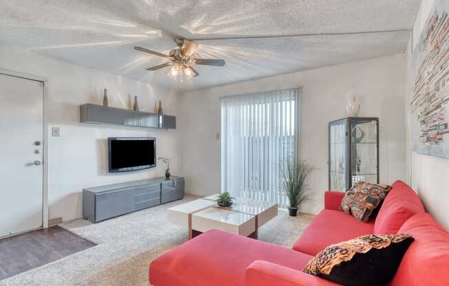 a living room with a red couch and a white coffee table