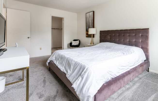 a bedroom with a bed and a desk and a tv