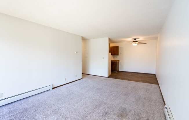 an empty living room with carpet and a ceiling fan. Eagan, MN Glen Pond Apartments