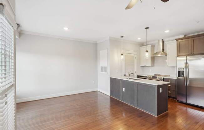 A kitchen with a wooden floor and stainless steel appliances.