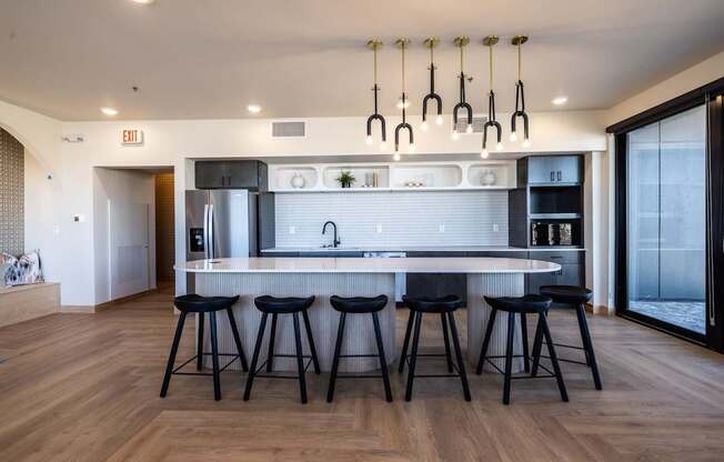 A modern kitchen with a white countertop and black bar stools.