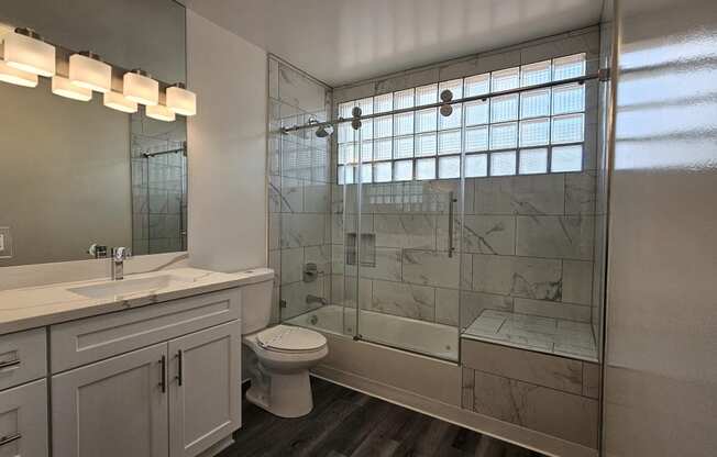 a bathroom with a shower and a sink and a toilet