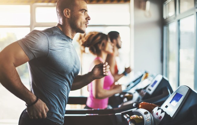 a man running on a treadmill in a gym