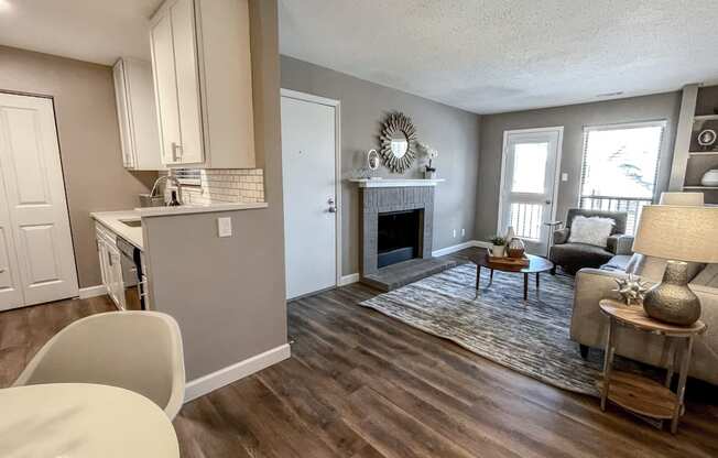 the view of the living room from the dining room and the kitchen with a fireplace