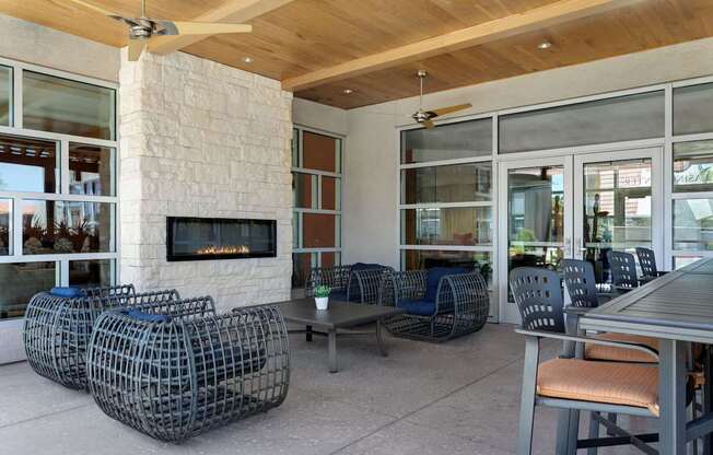 A patio with a fireplace and chairs at Denim Scottsdale, Scottsdale, AZ
