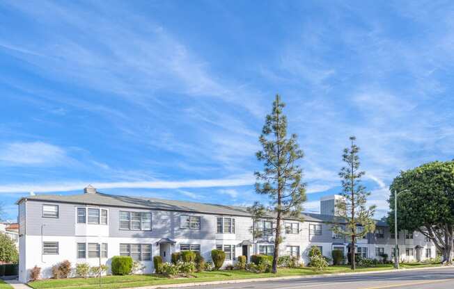 an apartment building on the corner of a street with a blue sky