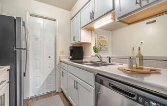 A kitchen with white cabinets and a black refrigerator at West Wind Apartments, Fort Wayne, 46808