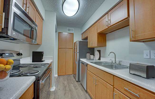 A kitchen with wooden cabinets and a stove top oven.
