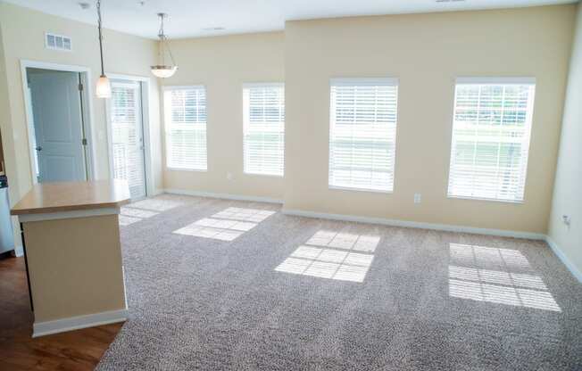an empty living room with blinds on the windows