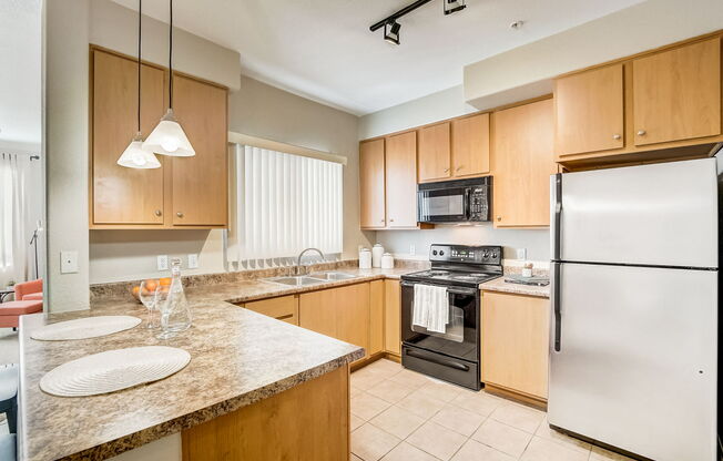 full kitchen with granite counter tops and stainless steel appliances at Adiamo Palm Valley, Goodyear