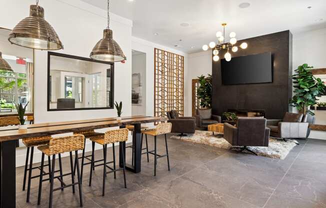 a bar area with stools and chairs and a large screen tv on the wall