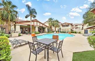 lounge chairs and table near swimming pool