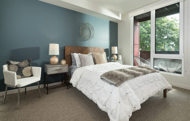 A bedroom with a large bed and a chair. at Ravello Apartments, Redmond, Washington