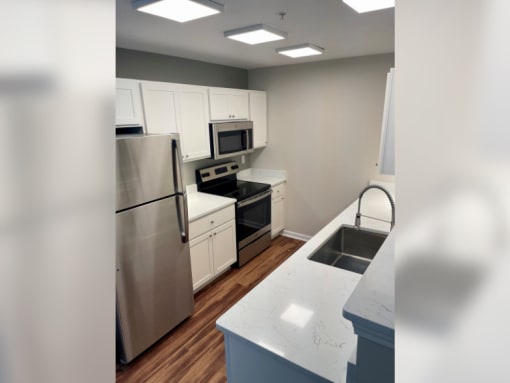 a kitchen with white cabinets and stainless steel appliances