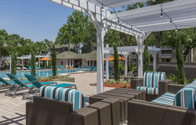 a pool area with lounge chairs and umbrellas