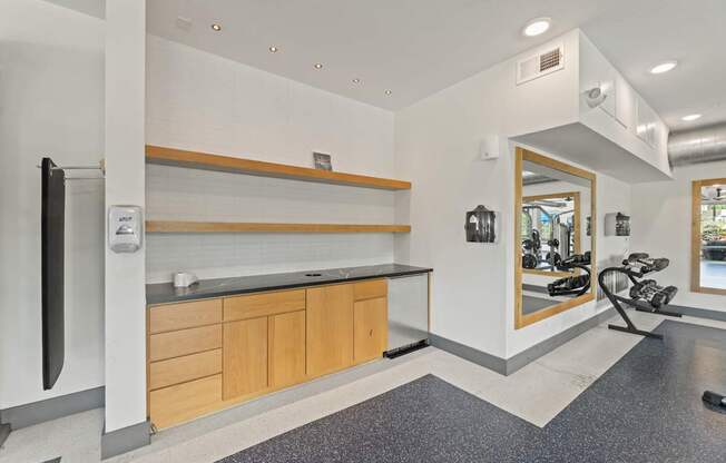 A modern kitchen with a refrigerator, countertop, and a view of the outside through a window.