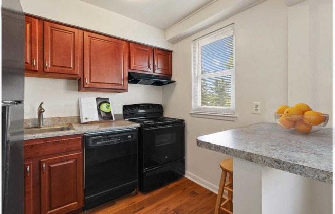 Kitchen with black appliances and breakfast bar at Donnybrook Apartments, Towson, MD, 21286