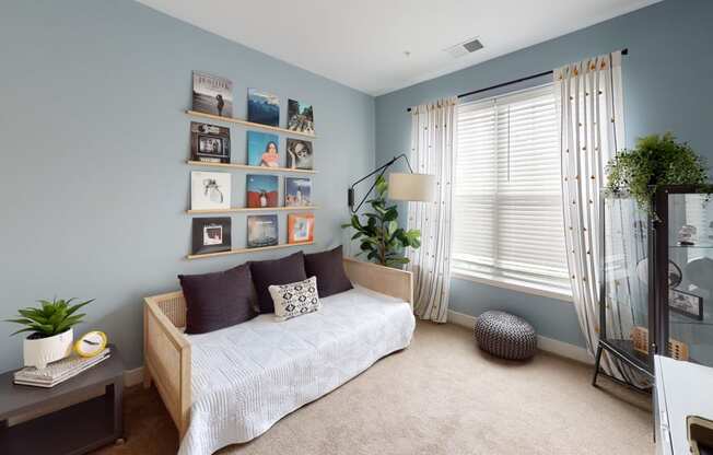 a bedroom with blue walls and a bed with a white comforter at The Bend Arbordale, Williamsburg, VA