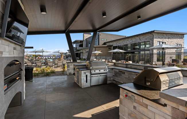 a view of the outdoor patio from the kitchen of a restaurant with a large window