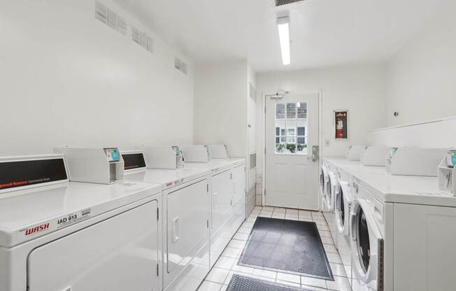 A laundromat with washers and dryers lined up.
