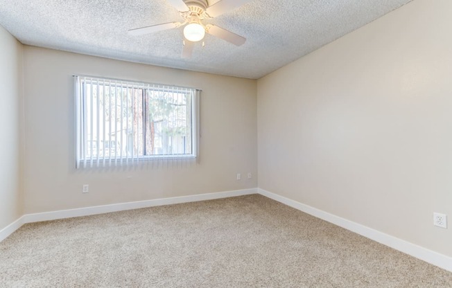 a bedroom with a ceiling fan and a window  at Redlands Park Apts, Redlands, 92373