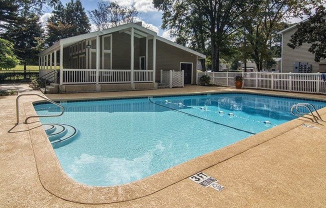A small pool with a white fence around it.