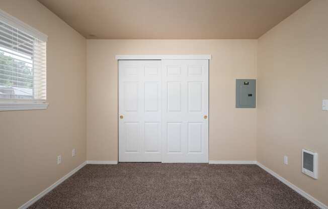 an empty room with carpet and a white door