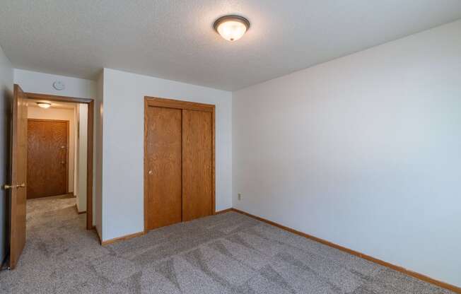 a bedroom with carpet and white walls. Fargo, ND Schrock Apartments