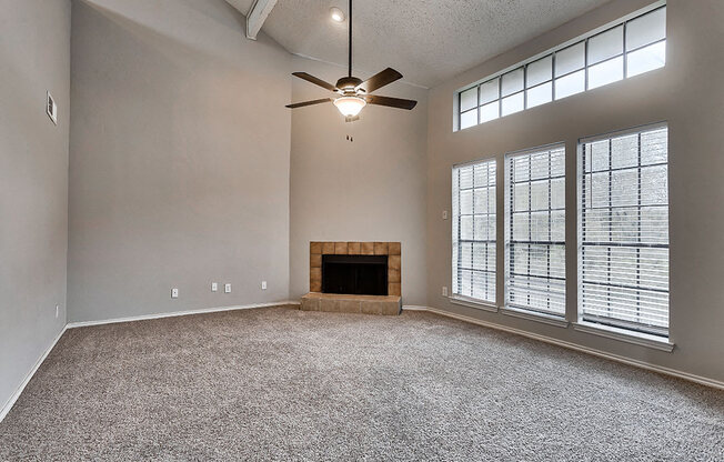 an empty living room with a fireplace and a ceiling fan at The Broadwater at Salado Creek, Texas