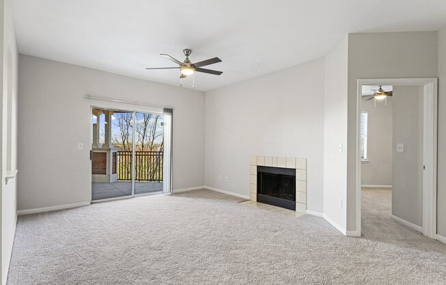 an empty living room with a fireplace and a ceiling fan at The Legends at Eagle Mountain Lake, Fort Worth