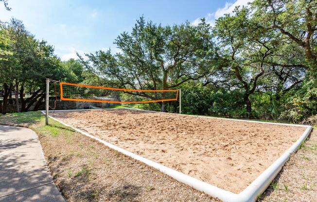 a volleyball court at the whispering winds apartments in pearland, tx at The Verandah, Austin, TX, 78726