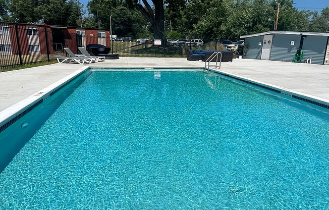 a large swimming pool with a blue sky in the background