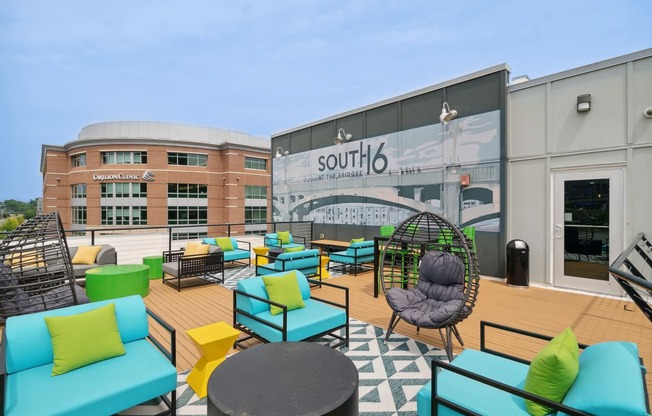 a patio area with couches and chairs and a mural on the side of a building