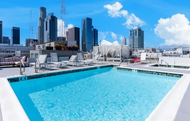 a rooftop pool with a city skyline in the background