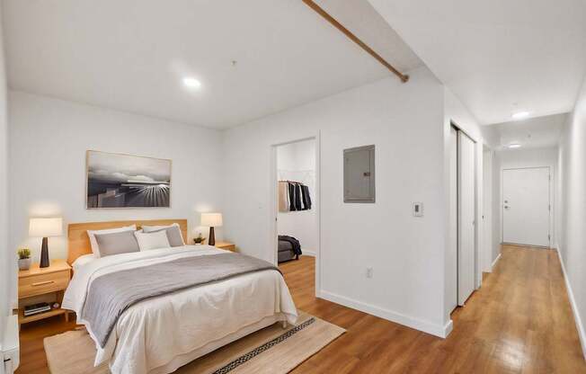 A bedroom with a large bed and a painting on the wall.