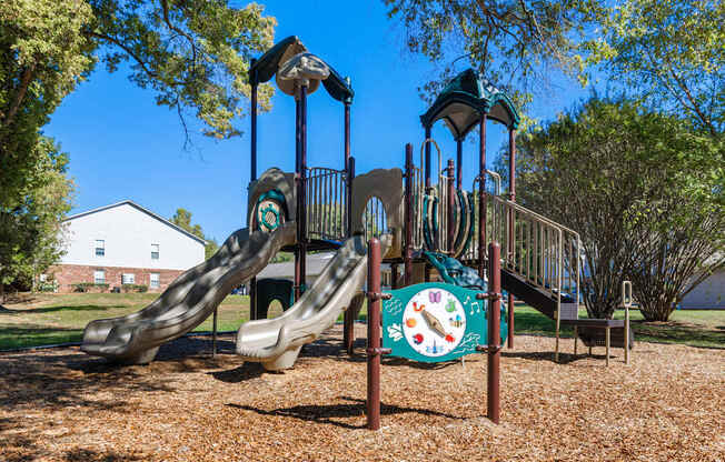 A playground with a slide and a clock on the side.