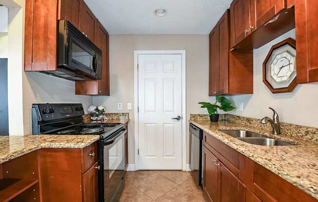 a kitchen with wooden cabinets and a black stove and a sink