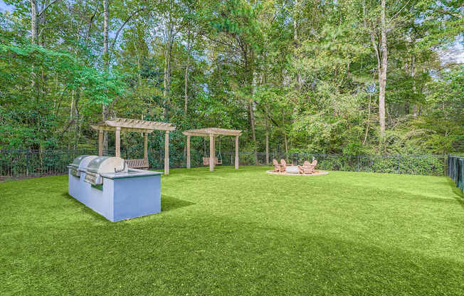 A backyard with a grill and a gazebo.