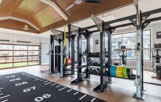 A gym with a wooden ceiling and a variety of equipment.