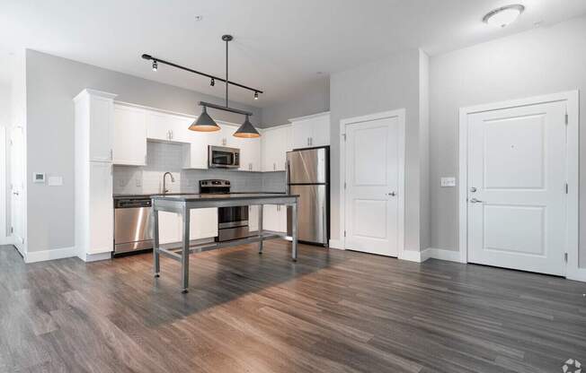 A modern kitchen with a wooden floor and white walls.at Century Baxter Avenue, Louisville Kentucky