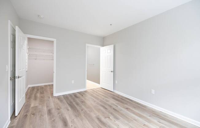 an empty room with white walls and wood flooring