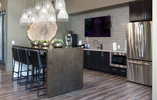 a kitchen with stainless steel appliances and a bar with chairs