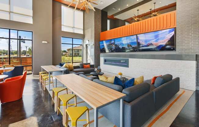 a lounge area with couches tables and chairs and large windows