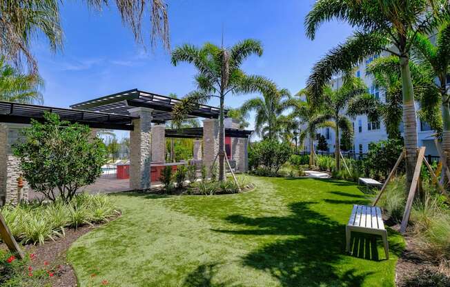 a garden with grass and palm trees at Altis Grand Lake Willis, Florida, 32821