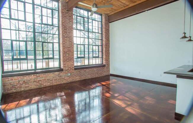 A room with a large window and a ceiling fan.