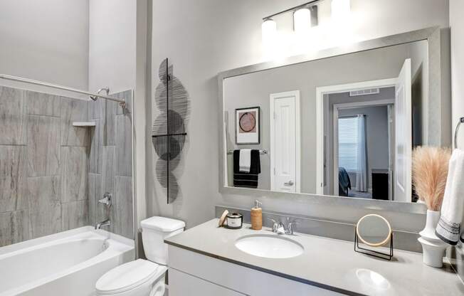 a bathroom with a sink and a mirror and a bath tub