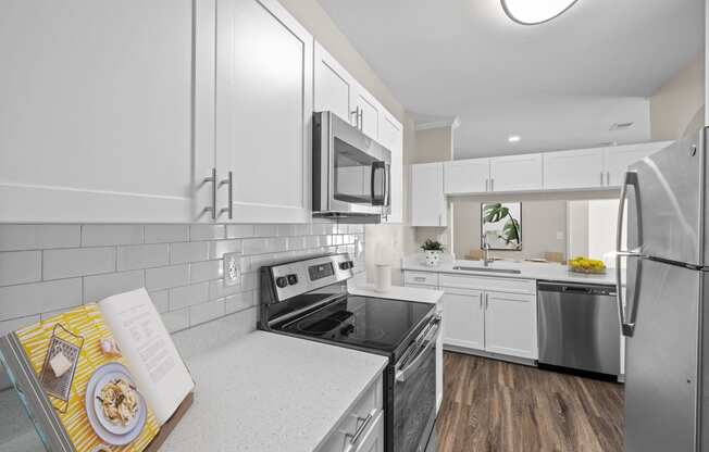 a kitchen with white cabinets and stainless steel appliances