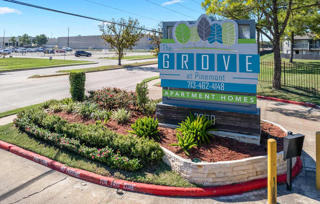A sign for The Grove apartment homes sits in front of a landscaped area.