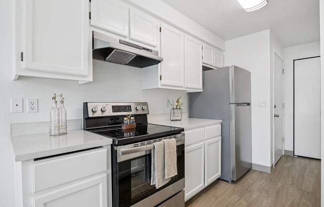A modern kitchen with white cabinets and a black stove top.