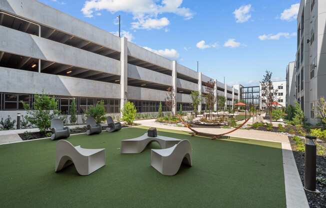 a courtyard with benches and grass in front of a building